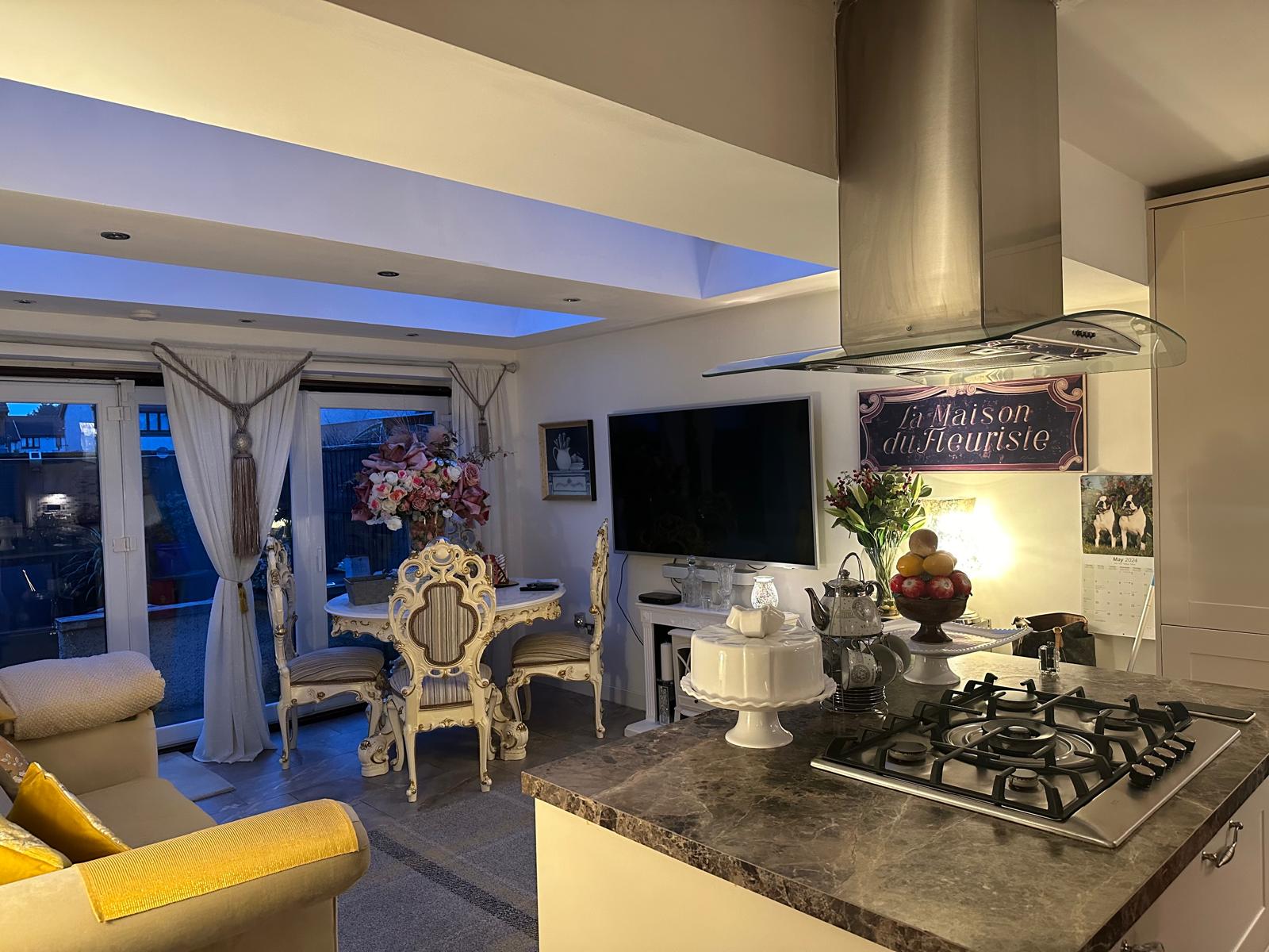 Open-plan kitchen and dining room with a granite-topped island, gas hob and extractor hood, cleaned and set out